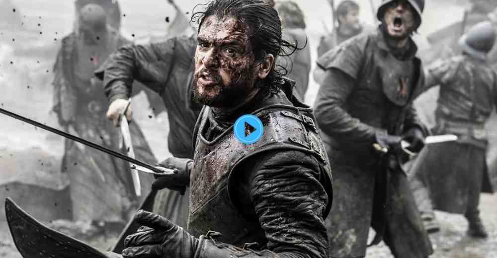 Jon Snow in bloody armor fighting during a chaotic battle scene in Game of Thrones.